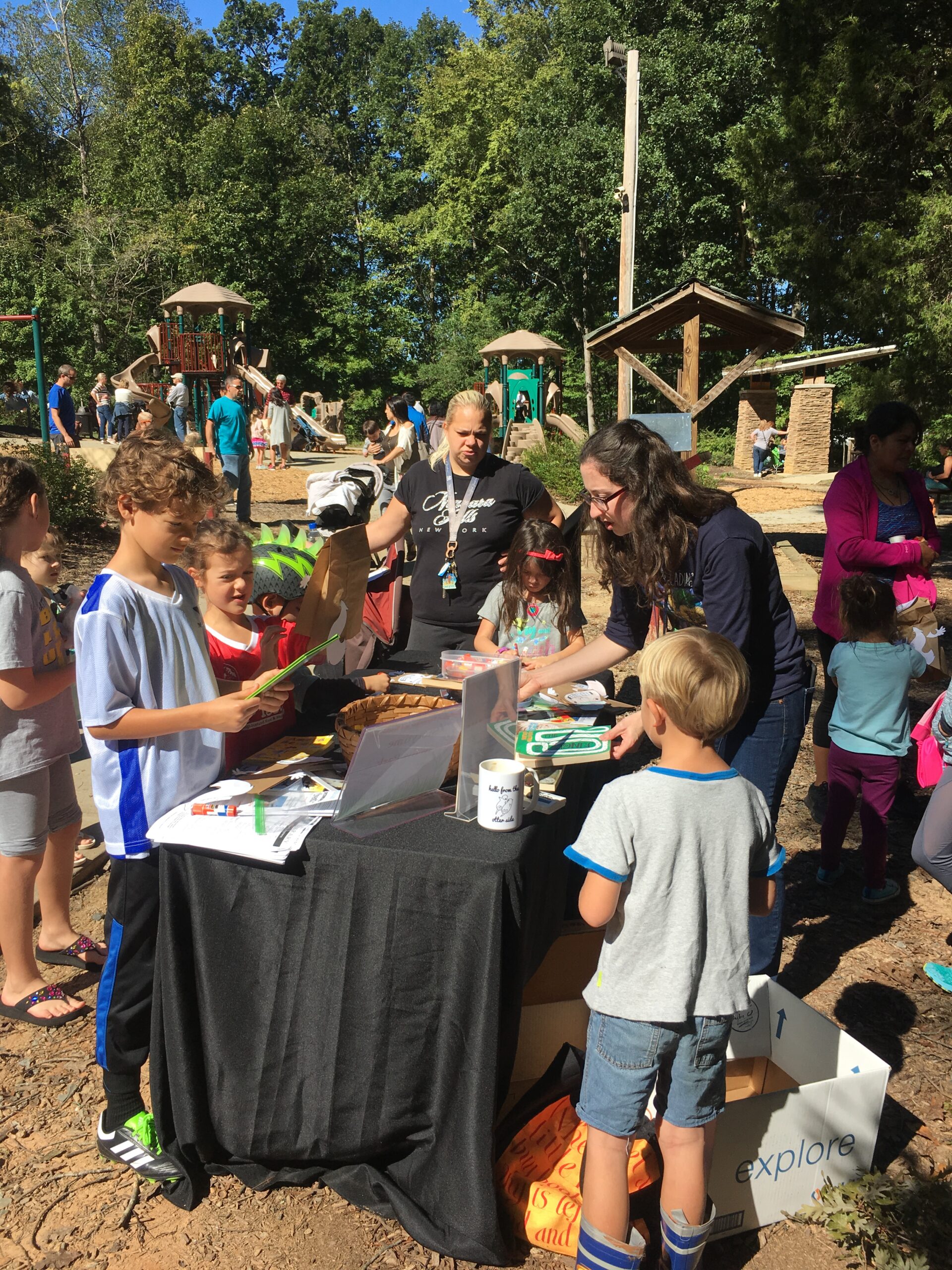 Kids gathering around a learning station at a Kids in Nature Day event.
