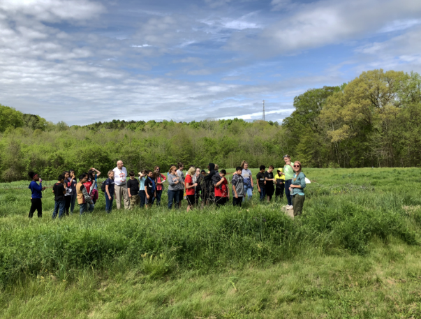 A group of people standing in a field at Lomax Farm.