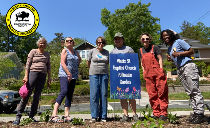 Six women standing behind a pollinator garden they created at Watts Baptist Church.