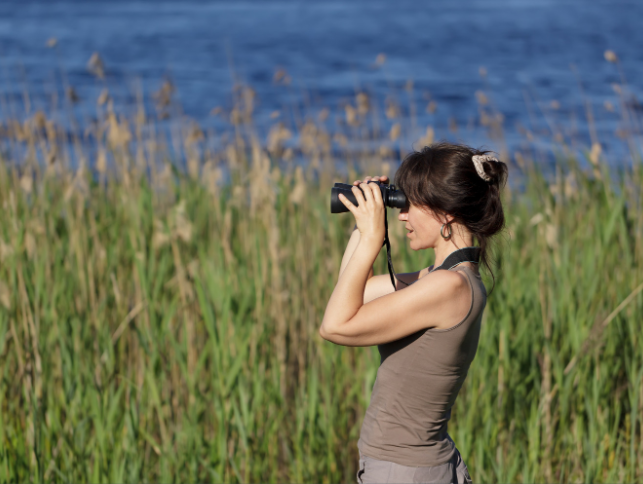 A woman looking through binoculars.
