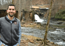 JOEY OWLE, SECRETARY OF AGRICULTURE FOR THE EASTERN BAND OF
CHEROKEE INDIANS, IN FRONT OF ELA DAM—THE ONLY DAM KEEPING
THE OCONALUFTEE RIVER FROM BEING COMPLETELY FREE-FLOWING. (Photo credit: David Boraks, WFAE)