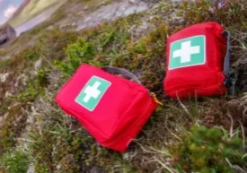 Two first aid packs sitting on the ground.