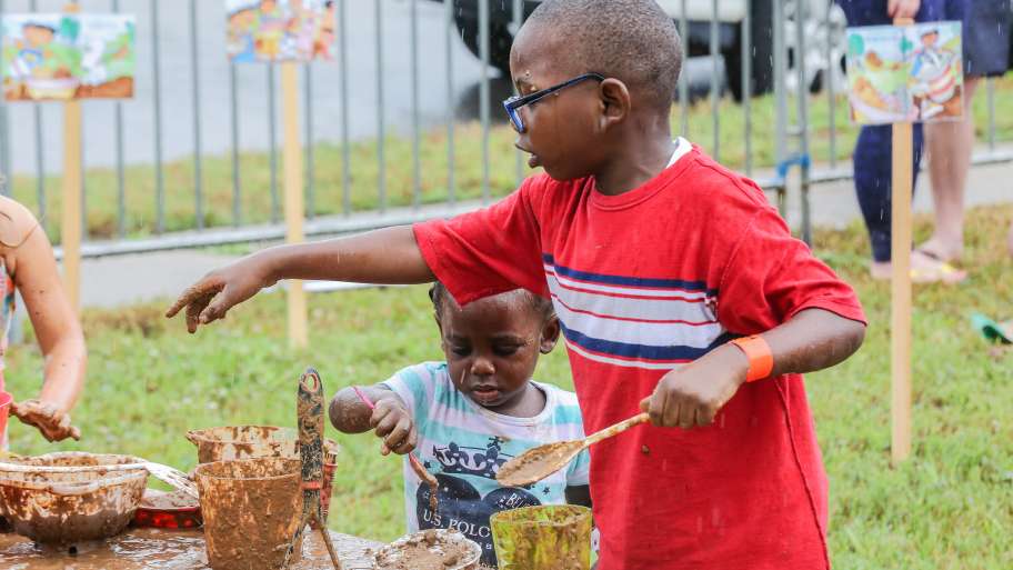 Children making mud pies at Mud Day.